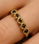 Anel dourado com pedras negras